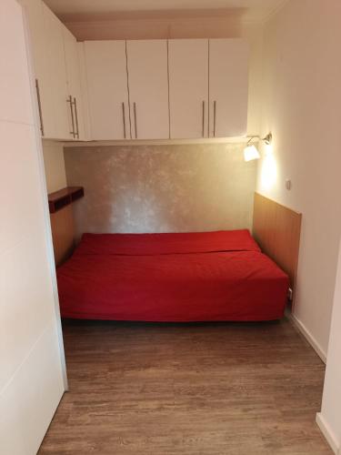 a red bed in a small room with white cabinets at El Paso Unin 1 in Unin