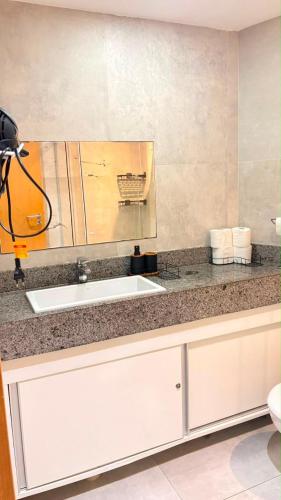 a kitchen counter with a sink and a mirror at Flat Paiva Bugam - Paiva Home Stay in Recife