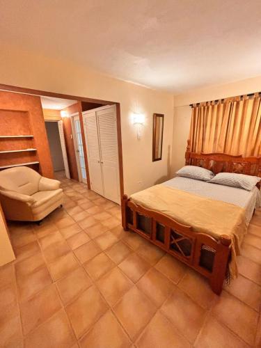 a bedroom with a bed and a chair in it at Serenity Garden Escape in Port-of-Spain