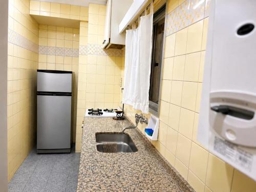 a kitchen with a sink and a refrigerator at Peatonal Sarmiento in Mendoza