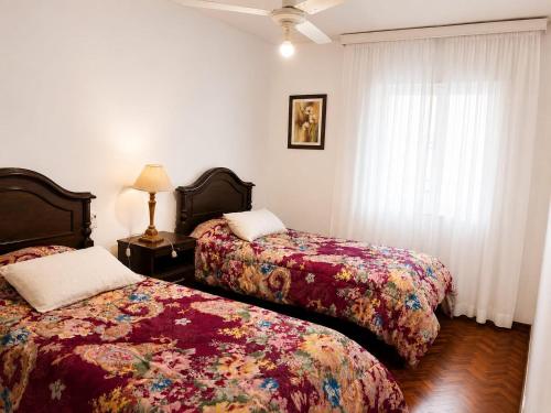 a bedroom with two beds and a window at Peatonal Sarmiento in Mendoza
