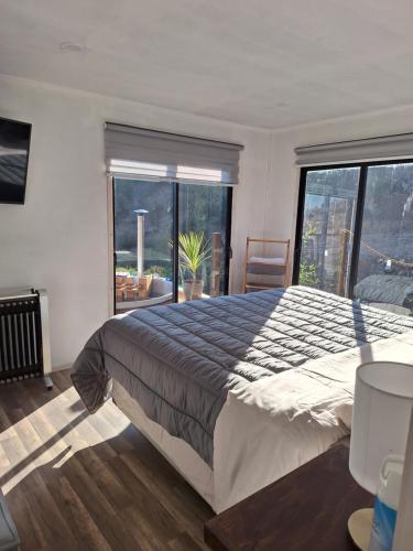 a bedroom with a large bed and a large window at Tu rinconcito entre cerros in Requínoa