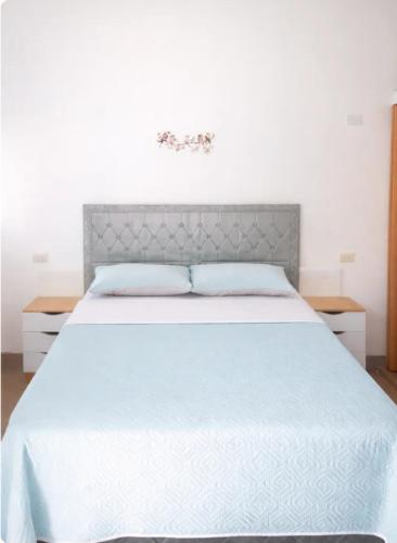 a bedroom with a large white bed with blue pillows at Como en Familia in Esquipulas