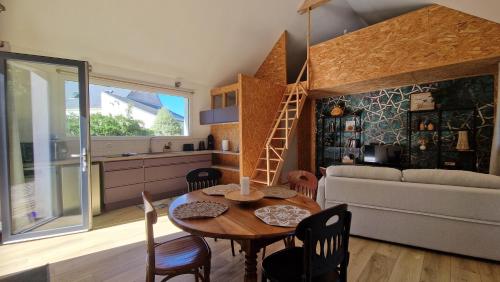 a kitchen and living room with a table and a couch at Ty ar C'hoad in Sulniac