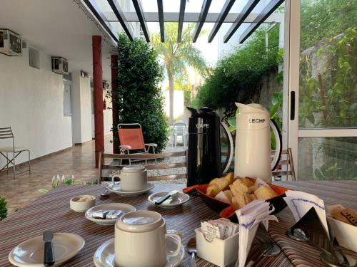 a table with a tray of bread and cups and coffee at Hostería Boulevard in Villa María
