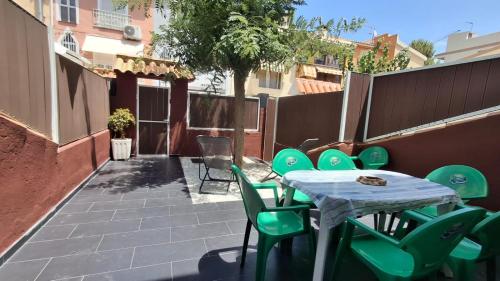 a table with green chairs sitting on a patio at Villaparadisi in Benicàssim