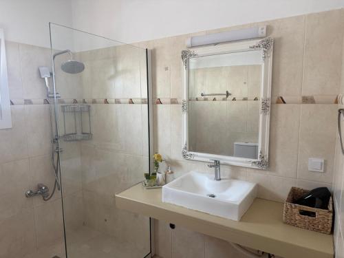 a bathroom with a sink and a shower with a mirror at Sea La Vie in Nikiana