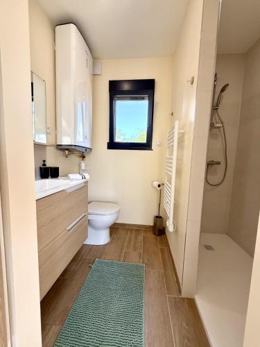 a bathroom with a toilet and a sink and a window at Le Cocon de May entre Terre et Mer a proximité de caen in May-sur-Orne
