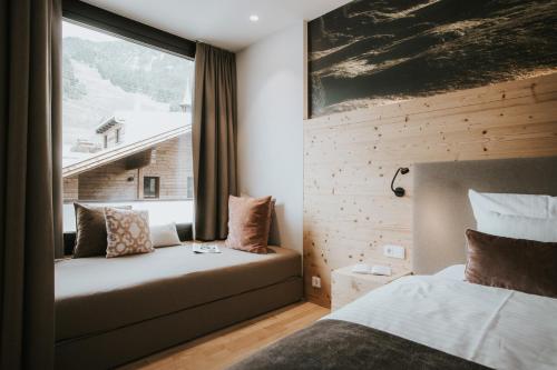 a hotel room with a bed and a window at Landhaus Albert Murr inkl Premium Sommerkarte in Sankt Anton am Arlberg