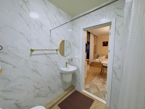 a white bathroom with a sink and a mirror at Rusa in P'eria