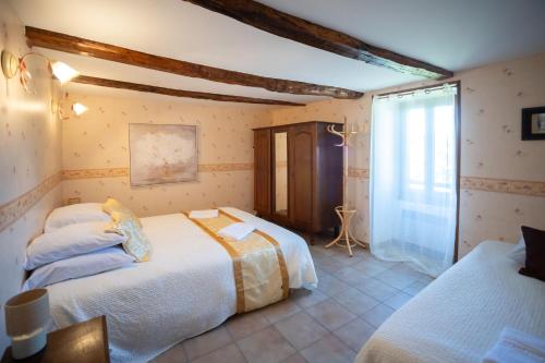 a bedroom with two beds and a window at Le refuge à la campagne in Toulonjac