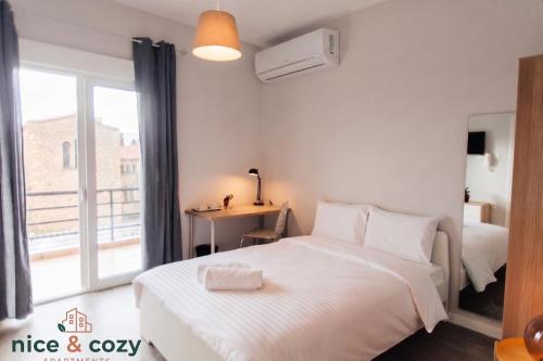 a bedroom with a white bed and a window at Nice and Cozy Apartments in Néa Khilí