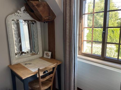 a mirror sitting on a table next to a window at Bienvenue chez Chris ! in Saint-Hilaire-des-Landes