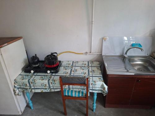 a small kitchen with a stove and a sink at myGrandma's home in Sheki