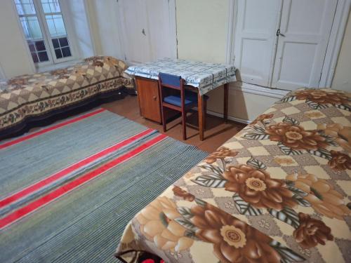 a room with two beds and a table and a couch at myGrandma's home in Sheki