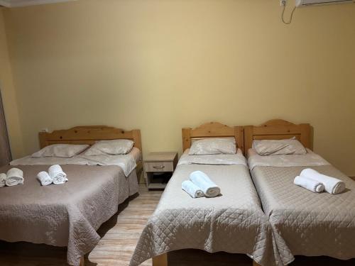 two beds in a room with towels on them at glory hotel kobuleti in Kobuleti