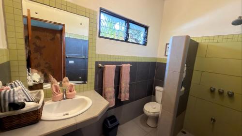 a bathroom with a sink and a toilet and a window at The Inner Light Yoga Lodge in Sámara