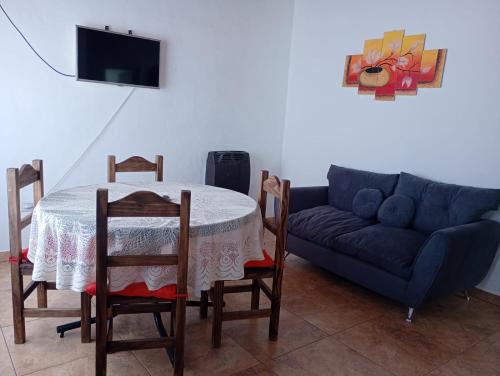 a living room with a table and a blue couch at Casa VYB in Malargüe