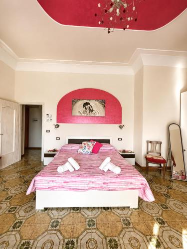 a bedroom with a large bed with a pink comforter at Il Borgo in Agerola