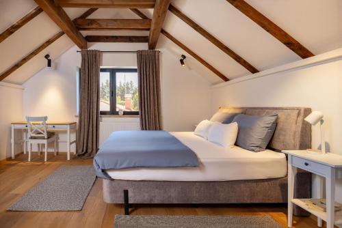 a bedroom with a bed and a desk and a window at Holiday Residence Banfi in Štrigova