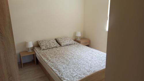 a small bedroom with a bed and two night stands at Domek letniskowy Pod Topolami in Sieraków