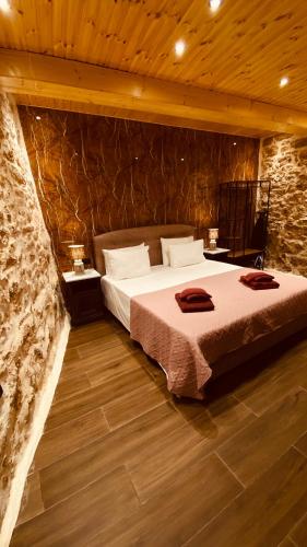 a bedroom with a bed and a stone wall at Casa Stratigos in Corfu