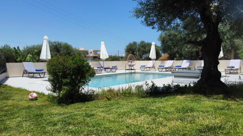 ein Swimmingpool mit Liegestühlen und Sonnenschirmen in der Unterkunft Villa Daratso with private heated pool view to the sea in Daratso