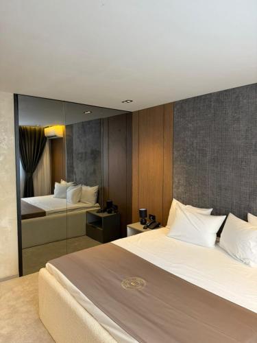 a hotel room with two beds and a mirror at Fron Hotel in Prishtinë