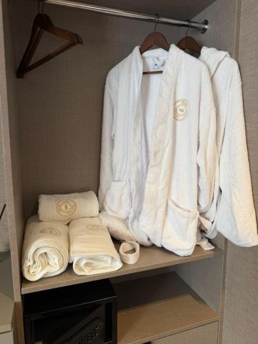 a closet with white towels on a shelf at Fron Hotel in Prishtinë