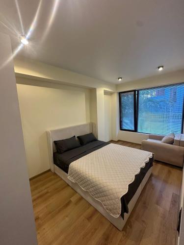 a bedroom with a large bed and a couch at Toidze's apartment1 in Kobuleti