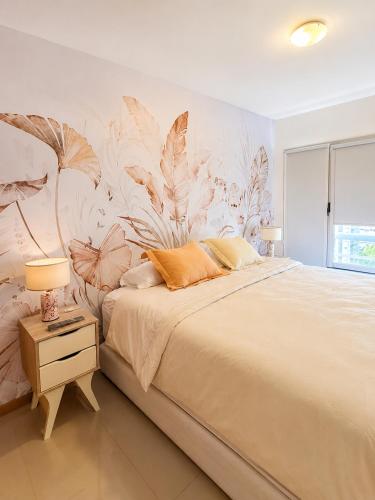 Ein Schlafzimmer mit einem großen Bett und einer floralen Tapete. in der Unterkunft AC Suites in Puerto Madryn