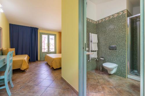 a room with a bathroom with a toilet and a shower at Hotel Del Corso in Pula