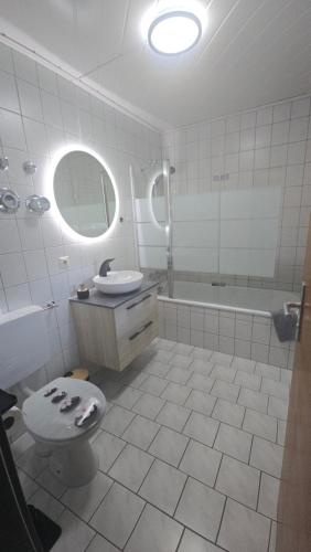 a bathroom with a toilet and a sink and a tub at InnJoy! in Friedrichshafen