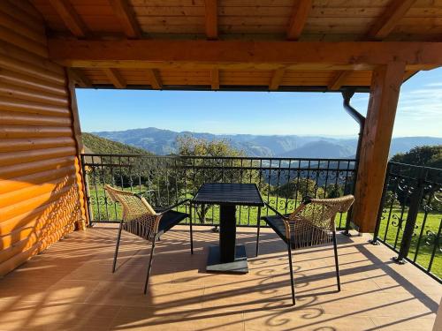 a table and chairs on a deck with a view at Apartment Boris Sveta Planina in Knezdol