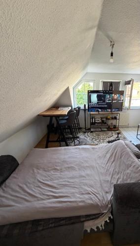 a bedroom with a bed and a desk and a tv at Gemütlicher Aufenthalt mit Netflix & perfekter Anbindung! in Elmshorn