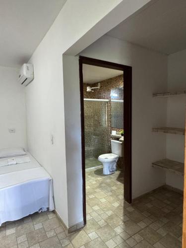 a bathroom with a bed and a toilet in a room at Pousada Plenamar in Maragogi