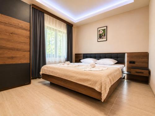a bedroom with a large bed and a window at Къща за гости ЕМ Парадайс in Tserova Koriya