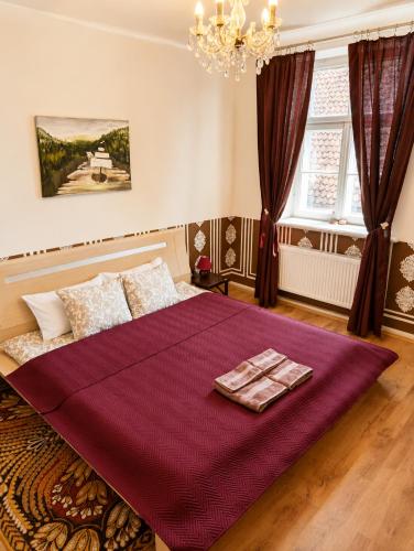 a bedroom with a large bed with a purple blanket at Arāja apartamenti in Kuldīga