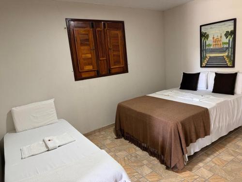 a bedroom with two beds and a window on the wall at Pousada Plenamar in Maragogi