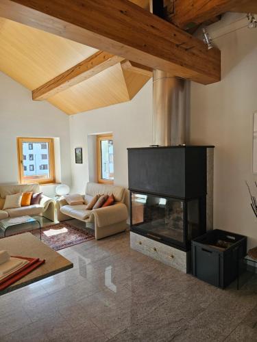 a living room with a fireplace and a couch at Cà ai Camòss, DUPLEX deluxe - centro paese in San Bernardino