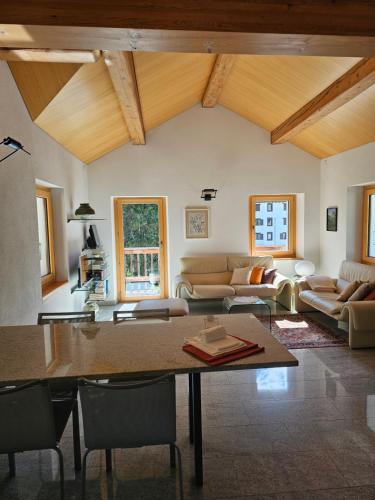 a living room with a table and a couch at Cà ai Camòss, DUPLEX deluxe - centro paese in San Bernardino