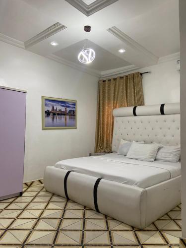 a bedroom with a large white bed in a room at Hollysee Hotel & Suites in Baruwa