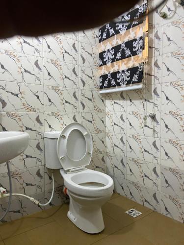 a bathroom with a toilet and a sink at Hollysee Hotel & Suites in Baruwa