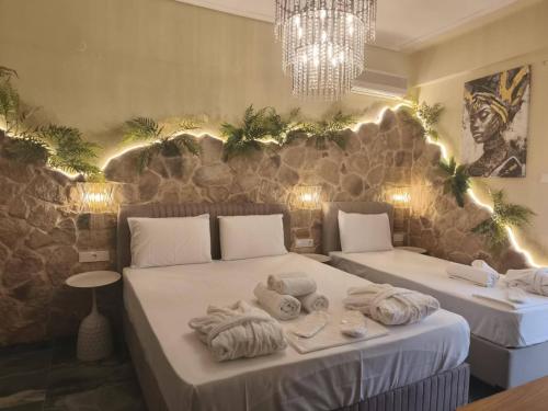 a room with two beds with towels and a chandelier at Faros in Platamonas