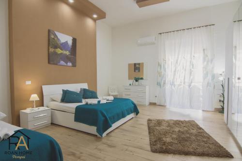 a bedroom with a bed with a blue comforter and blue pillows at Roan home Pompei in Pompei