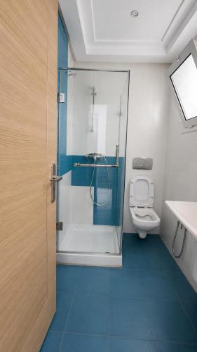 a bathroom with a shower and a toilet in it at Residence Golden Beach au bord de la mer in Bin Rhilouf