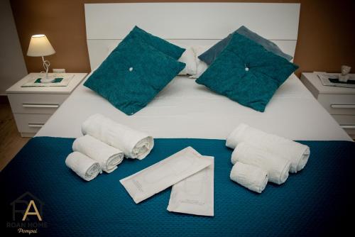 a bed with folded towels and a pile of towels at Roan home Pompei in Pompei