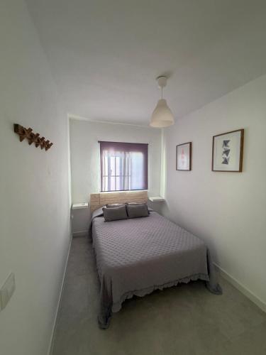 a bedroom with a bed in a white room at San Calixto 8 in Sanlúcar de Barrameda