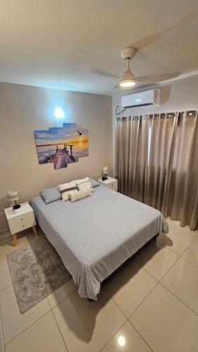a bedroom with a large bed and a window at The little Heaven in Baie Nettle