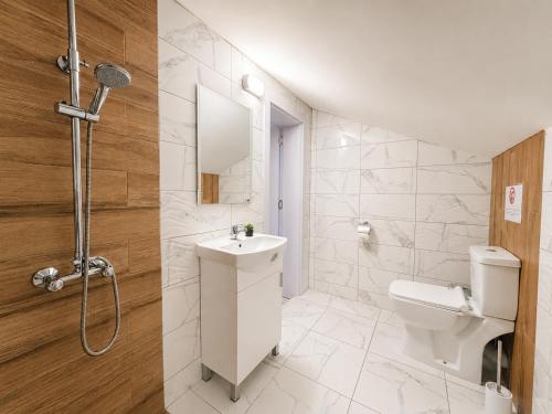 a white bathroom with a sink and a toilet at Къща за гости ЕМ Парадайс 2 in Tserova Koriya